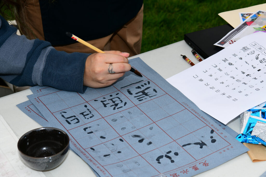 Student practicing calligraphy at world languages day